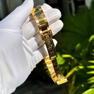 a hand holding a gold watch