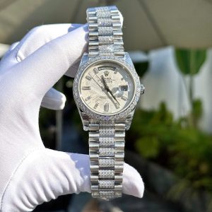 a hand in a glove holding a silver watch